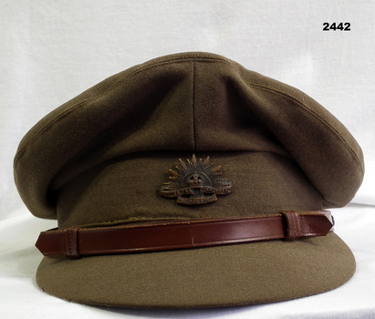 Khaki peak cap with rising sun badge.