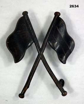 Crossed flags badge relating to Signals.