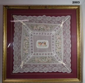 Embroidered silk, lace inserts, framed cloth.