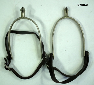 Set of metal spurs with leather straps.