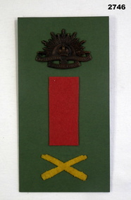 Card with rising sun badge and crossed weapons badge.