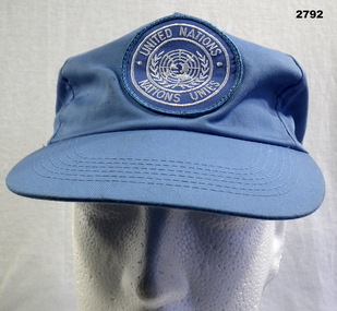 Blue peak cap with United Nations logo.