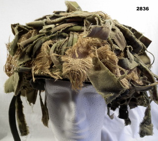 Steel helmet with camouflage covering.