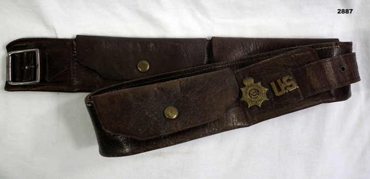 Brown leather belt with 3 pouches and badges on.