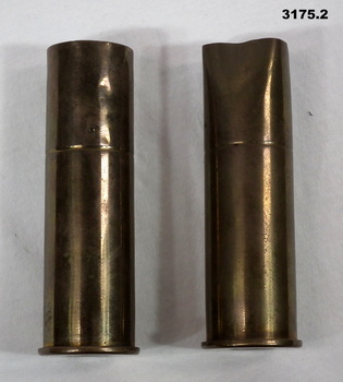 Two brass cannon cases used as vases.