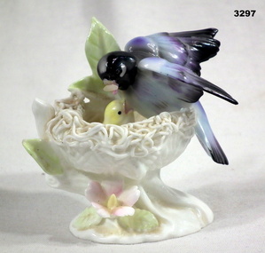 Porcelain memento of a bird feeding its young.