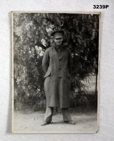 B & W photo of a soldier in a Great coat.