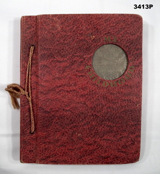 Small red photo album with photos over several countries.