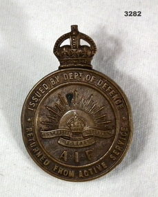 Brass circular returned from active service badge.