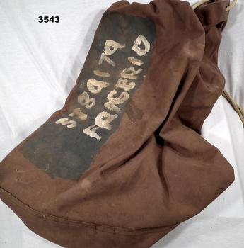 Brown kit bag with name stencilled on.