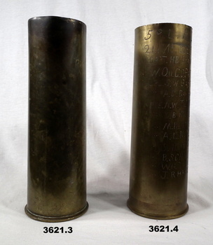 Two shell cases, one is engraved with names.
