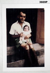 Photograph of a man with a baby.