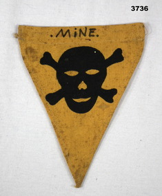 Triangular shaped badge of yellow cloth.