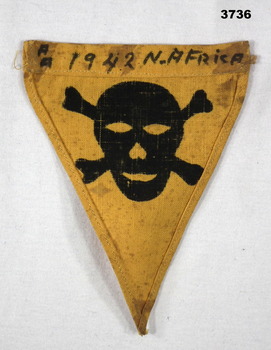 Triangular shaped badge of yellow cloth.