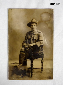 Sepia tone photo of a soldier sitting, WW1.