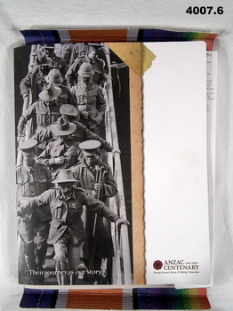Cardboard folder for education purposes containing books and photos.