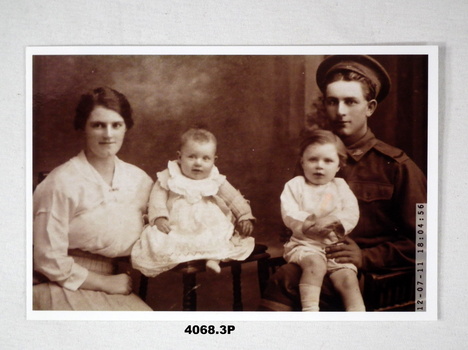 Sepia photo of a soldier with women and two children.