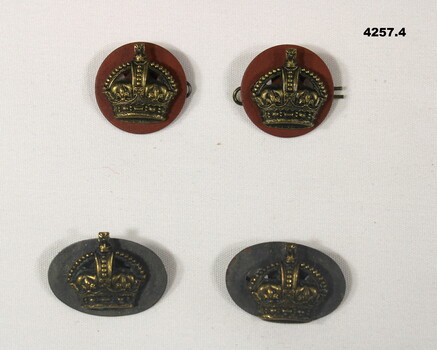 Four uniform badges in shape of a crown.