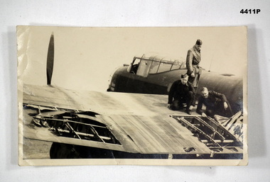 Air crew inspecting the damage to a Lancaster bomber.
