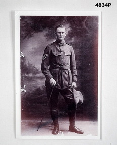 B & W photograph showing a standing soldier with 3 stripes