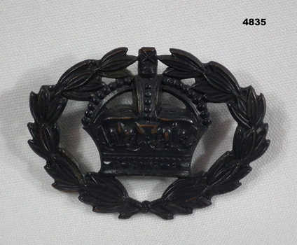 Black metal badge with crown, laurel leaves