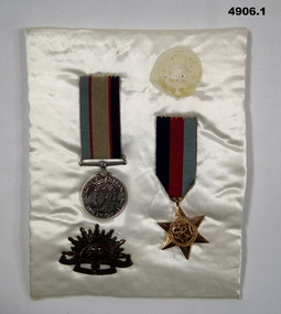 Two medals and badge on pad WW2