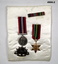 Two medals,  badge and ribbons on pad WW2