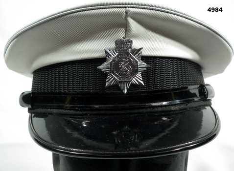 CAP, PEAKED, COMMISIONAIRES WITH METAL BADGE ATTACHED TO FRONT.