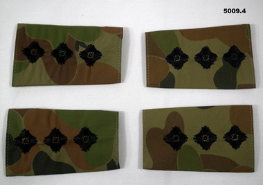 Four slide shoulder boards in camouflage pattern with captain's insignia.
