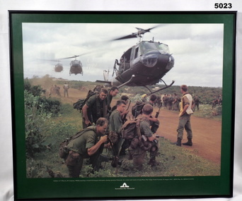Photograph of three helicopters coming in to land with soldiers in the foreground.