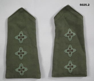 Two jungle green coloured slide shoulder boards with embroidered captain's pips.
