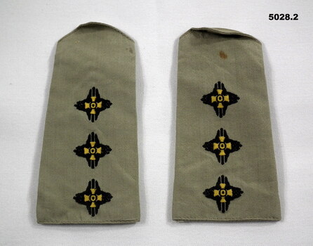 Two khaki coloured slide shoulder boards with embroidered captain's pips.