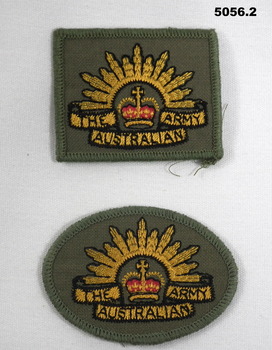 Two embroidered Australian Army Rising Sun cloth shoulder badges, one oval shaped and the other square.