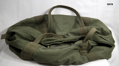Green army issue kit bag for carrying personal equipment.