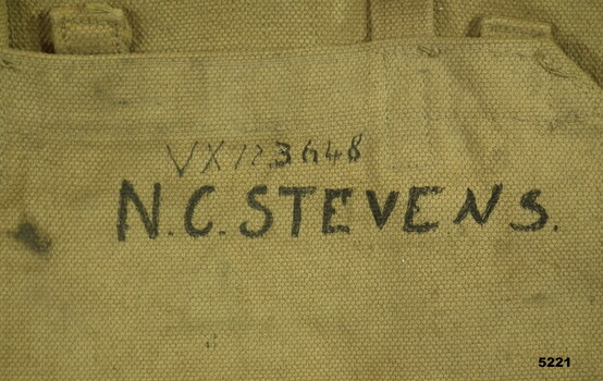 COTTON WEBBING BACK-PACK IN KHAKI. CLOSE UP OF NAME.
