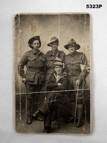 Photograph of four Servicemen, three Army, one Navy.