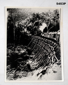 Photograph- black and white of an enemy train on a bridge.