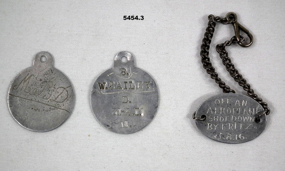 Three silver metal identity discs.