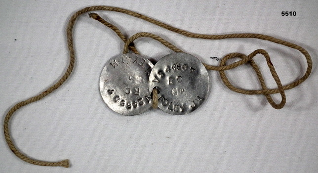 Silver coloured dog tag identity discs.