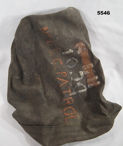 Dark brown labelled duffle bag with rope drawstring.