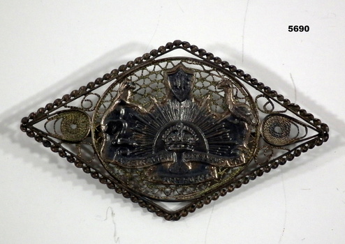 Rising sun brooch with filigree work around it.