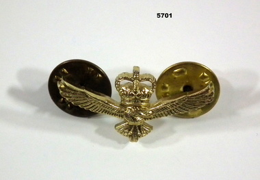 Small gold coloured metal lapel badge featuring a King's Crown and an eagle.