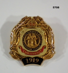 Gold plated badge in the shape of the first RSL badge.