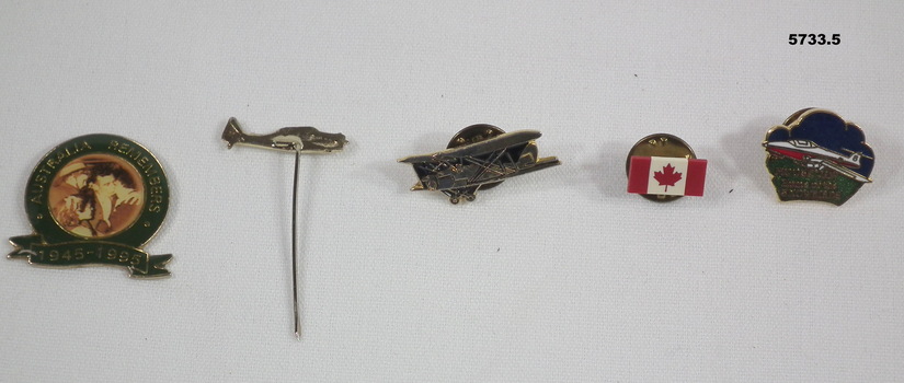 Collection of five lapel badges, three of which feature aircraft.