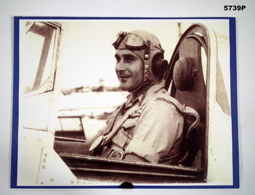 Black and white photograph of a pilot sitting in the cockpit of an aircraft.