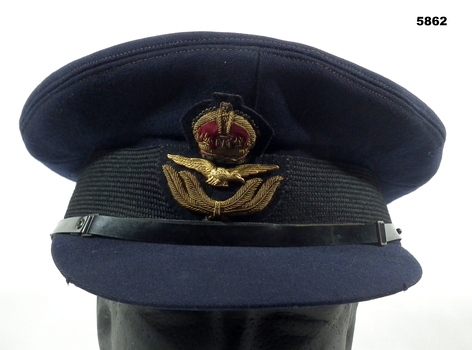 Blue RAAF peaked cap with a set of wings and crown on badge.
