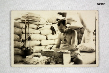 Small sepia photograph of a soldier writing.