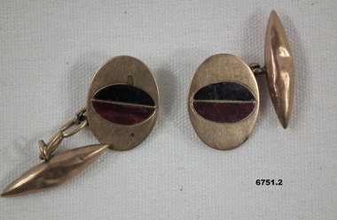 Gold coloured cuff links with purple insert.