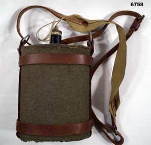 Felt covered water canteen with leather straps.
