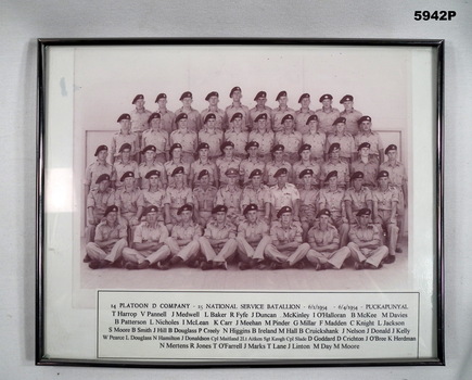Framed photograph with caption of a group of soldiers in uniform.